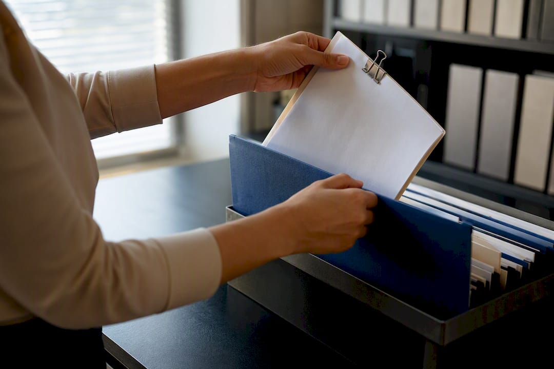 Hands filing paired fax records